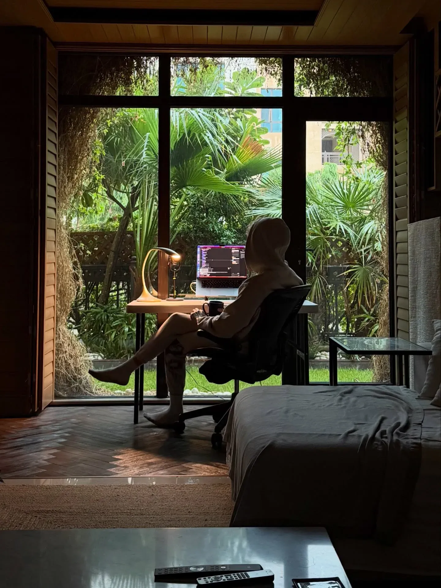 Joel coding by a garden window in Dubai